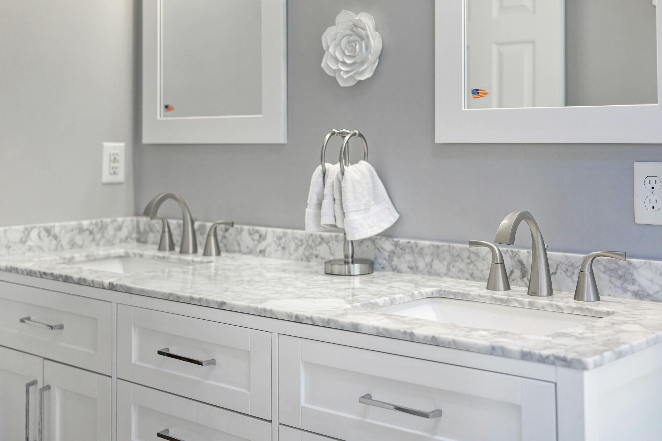 Elegant gray and white bathroom with marble countertop and dual sinks, highlighting interior design.